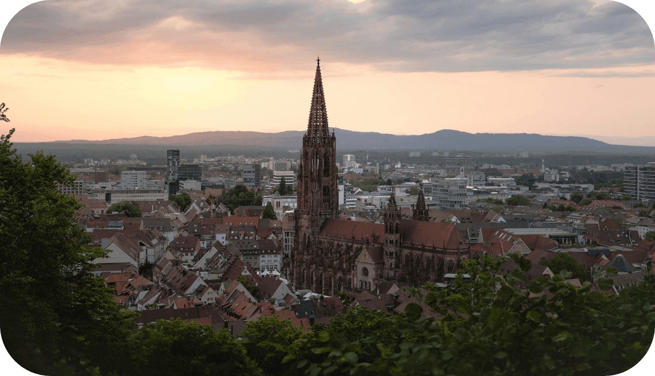 Foto von der Stadt Freiburg mit Sonnenuntergang im Hintergrund